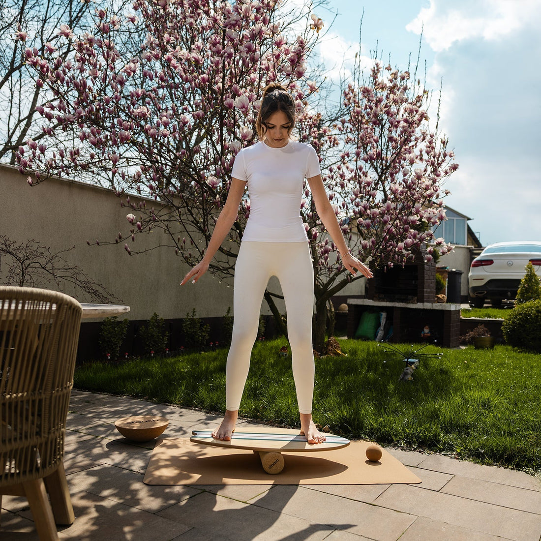 Frau trainiert mit STAASH Balance Board im Garten – Core und Koordination Training